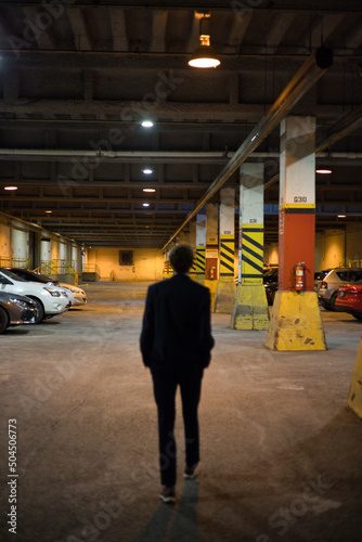 Silhouetted Figure in Garage with Cars