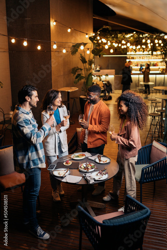 Happy diverse friends with drinks in restaurant