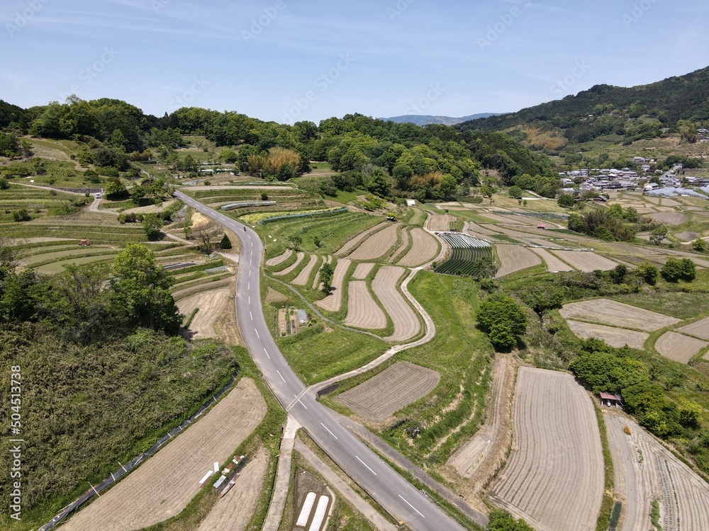 ドローンで空撮した日本の棚田を突き抜ける道路の風景