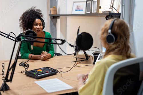 Happy diverse radio hosts recording podcast in studio photo