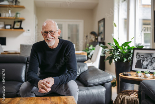 Older man on couch looking at camera. photo