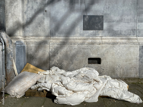 bed and duvet of homeless person on street photo