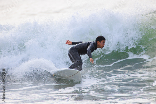 湘南の海でサーフィンをする男性 © D maborosi
