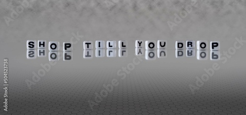 shop till you drop word or concept represented by black and white letter cubes on a grey horizon background stretching to infinity