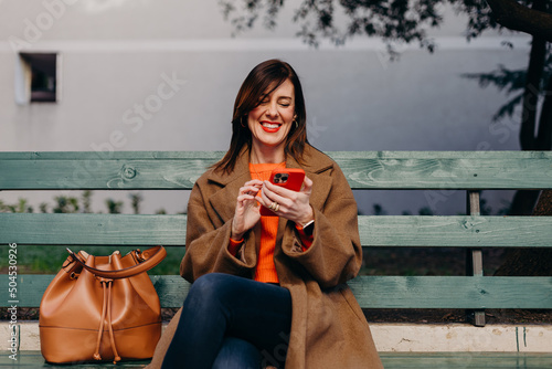Laughing lady checking notifications on smartphone photo