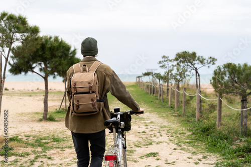 Backpacker man with bike in nature photo