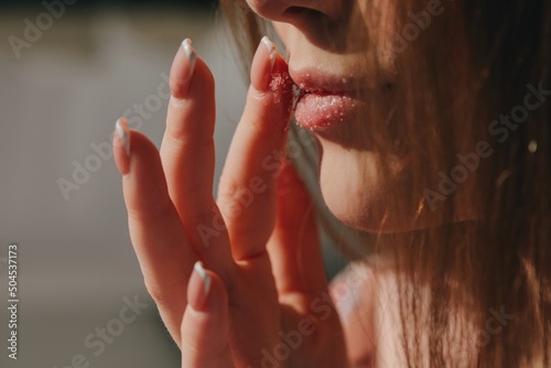 Anonymous woman use lip scrub - beauty portrait photo