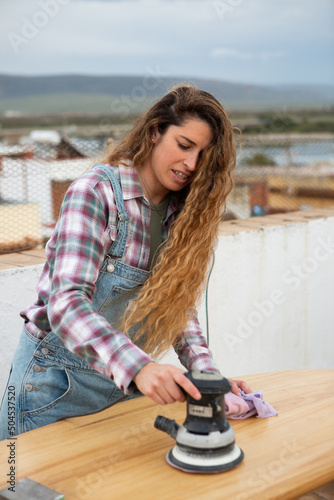 Surfer buffing her surfboard photo