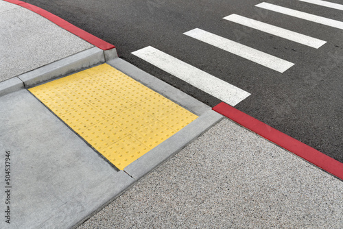 Closeup view at colorful crosswalk with tactile paving photo