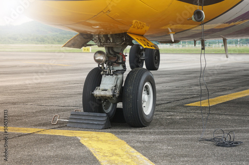 The airplane wheels are blocked by a chock block. Rubber wheel chock under the aircraft's wheels.