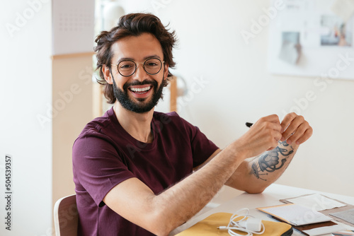 Cheerful male designer sitting at table