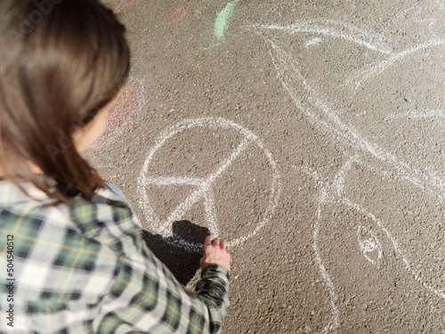 Woman drawing anti-war art with chalk on the street photo
