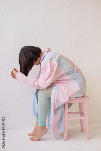 Anonymous depressed woman sitting on stool  photo