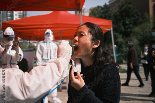 Asian Woman Receives A Throat Swab At A Community Testing Centre. photo