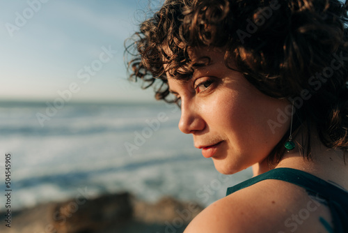 Woman lookint at camera over her shoulder photo