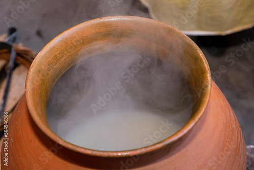 Clay pot with atole inside of it and smoke rising from the interior  photo