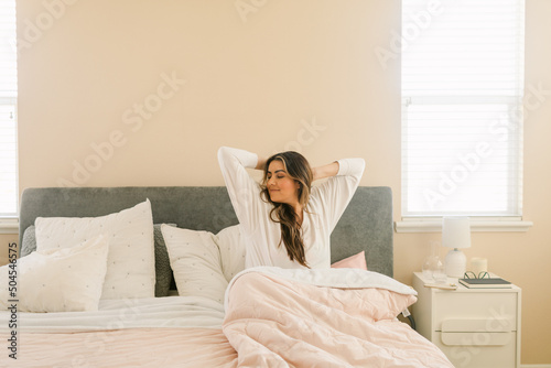 Woman gratefully waking up from bed photo