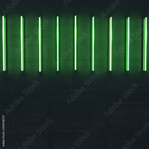 Some bright  green neon lights on a rough concrete wall. Horizontal alligned.