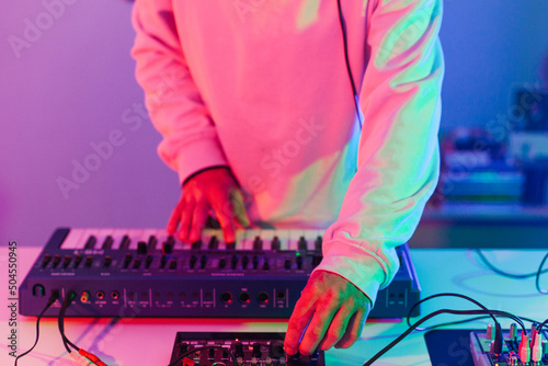 Unrecognizable male person playing synthesizer photo