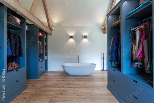 Modern dressing area in a renovated barn. Bathtub at the far end.