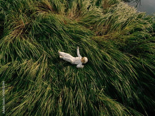 Astronaut lying on grass in nature photo