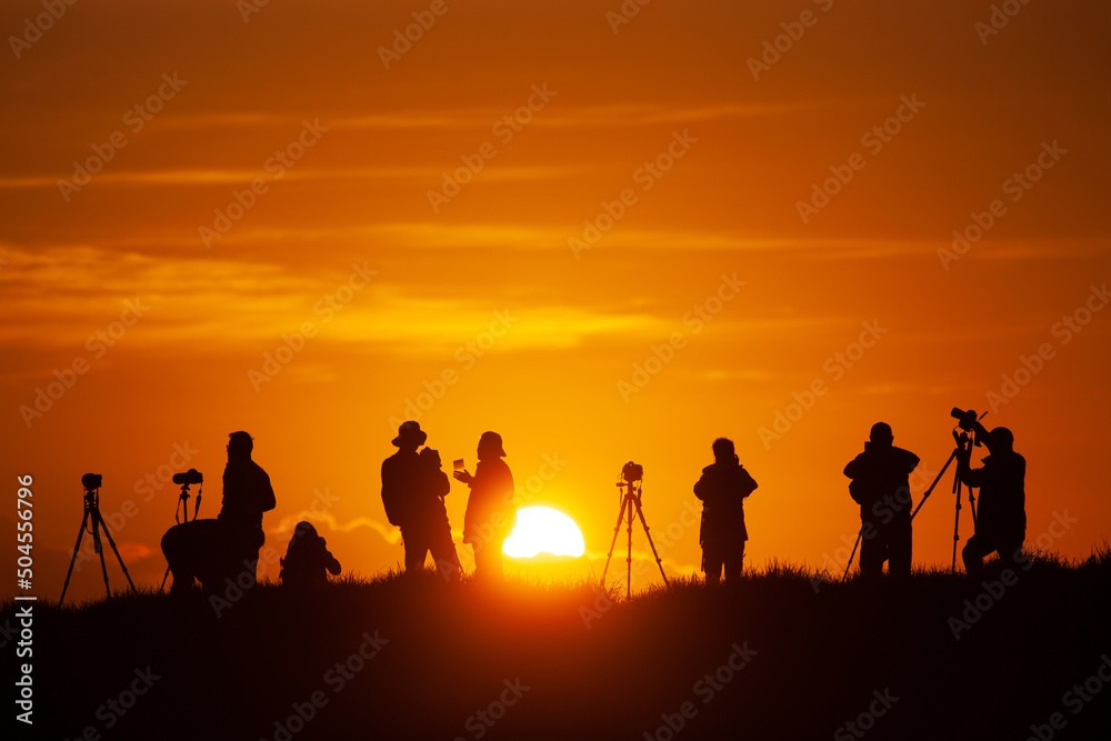 A group of photographers capture sunrise. 