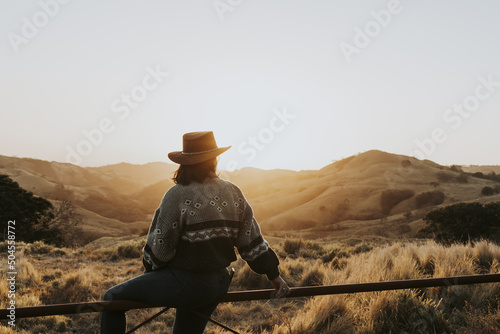 Woman with hat watching a sunset

