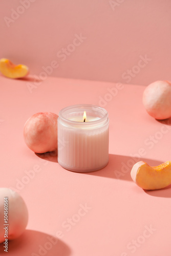 Candles and peaches closeup on a pink table photo