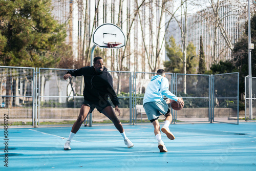 Young men playing basketball on an urban basketball court photo
