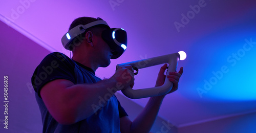 Man with virtual reality headset and joystic is playing game