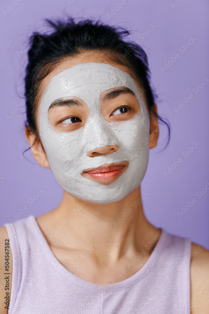 Young asian woman refreshing facial mask Young asian woman refreshing facial mask