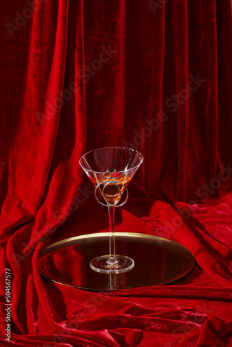 Wine glass on the glamour luxurious red velvet curtain photo