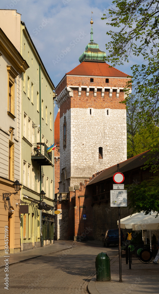 Pijarska street with Kraków Defensive Walls and St. Florian's Gate or Florian Gate (Brama Floriańska). Gothic tower, part of historic fortifications in the Old Town of Krakow, Poland. - obrazy, fototapety, plakaty 