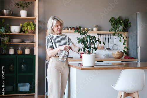 Woman watering plant at home photo