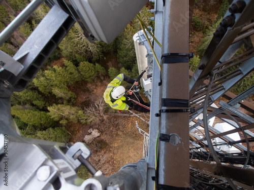 5G fiber optic technician on a telecommunication tower, hights working photo