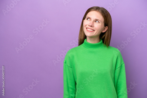 Young English woman isolated on purple background thinking an idea while looking up