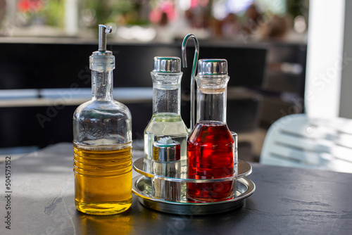 Bottles of olive oil, balsamic vinegar and wine stand on black table