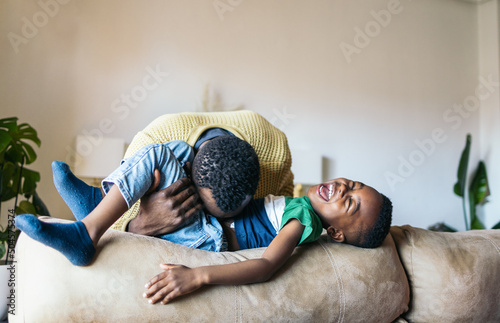 Father playing with his son at home photo