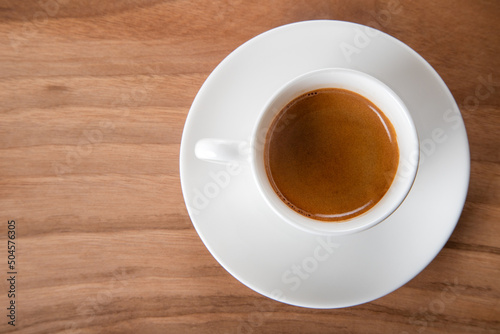 White cup of espresso on wooden background , directly above