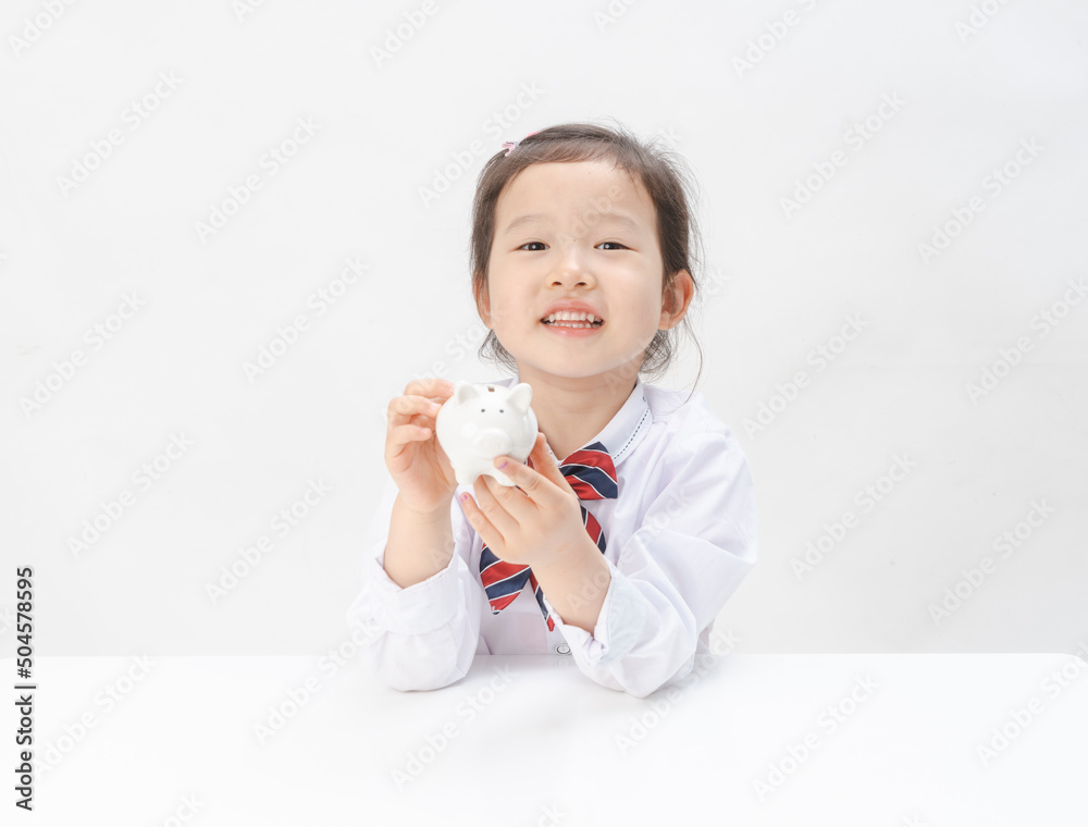 The lovely little girl has a piggy bank in her hand The lovely little girl has a piggy bank in her hand