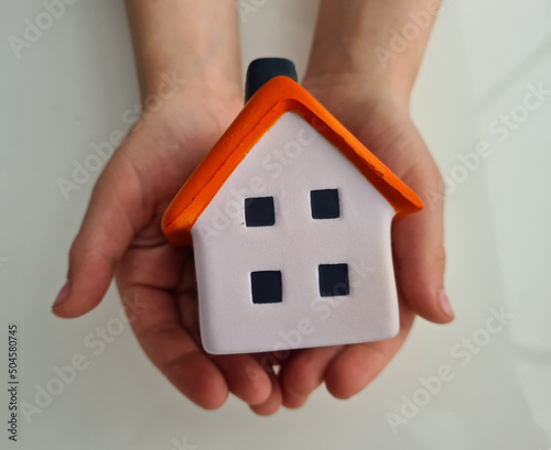 Hand protecting house and home insurance closeup