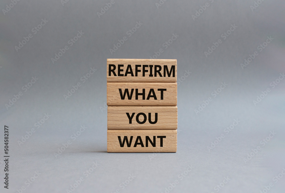 Goals symbol. Wooden blocks with words 'Reaffirm what you want'. Beautiful grey background. Business and 'Reaffirm what you want' concept. Copy space. Goals symbol. Wooden blocks with words 'Reaffirm what you want'. Beautiful grey background. Business and 'Reaffirm what you want' concept. Copy space.
