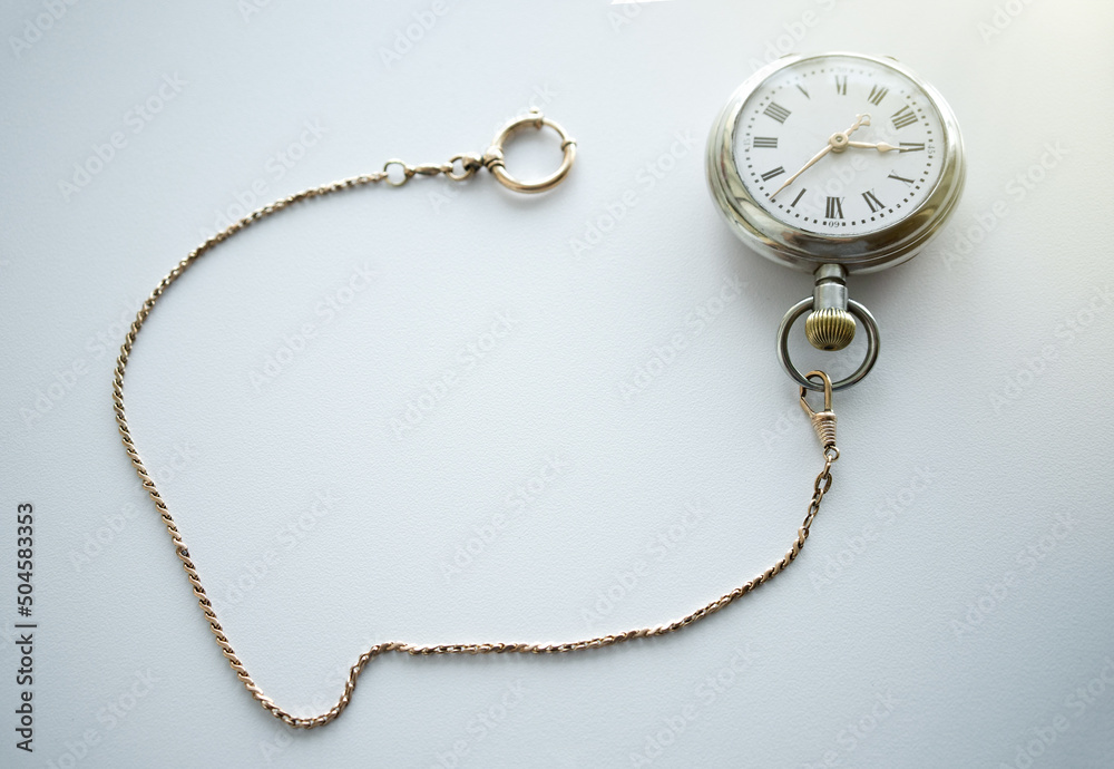 Pocket mechanical watch of the last century on a white background.Silver watch with gold chain. Pawnshop. Buying antiques.Search for old things.The passing time. Pocket mechanical watch of the last century on a white background.Silver watch with gold chain. Pawnshop. Buying antiques.Search for old things.The passing time.