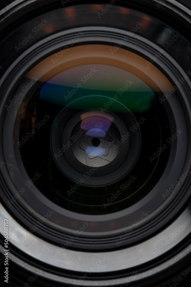 Professional camera photo lens. Details of glass, layer of enlightenment, aperture petals. Light reflections from modern diode lamps. The concept of making visual content. Vertical photo. Professional camera photo lens. Details of glass, layer of enlightenment, aperture petals. Light reflections from modern diode lamps. The concept of making visual content. Vertical photo.