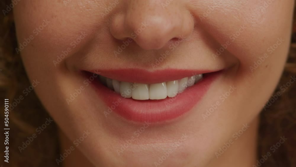 Close up of a charming woman smile with perfect natural teeth and bright lipstick Close up of a charming woman smile with perfect natural teeth and bright lipstick