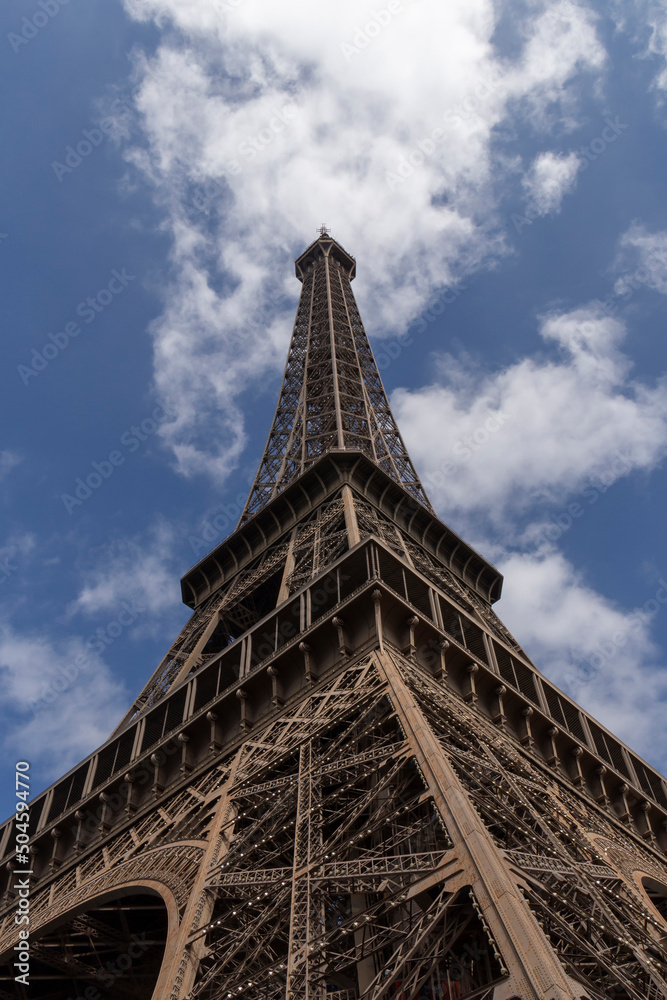 sight of Eiffel Tower in Paris against blue sky with white clouds