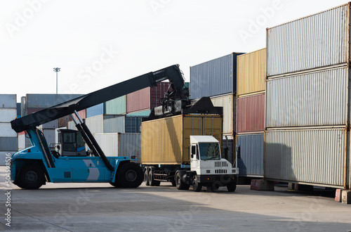 Top forklifts lifting 40 ft container from a truck