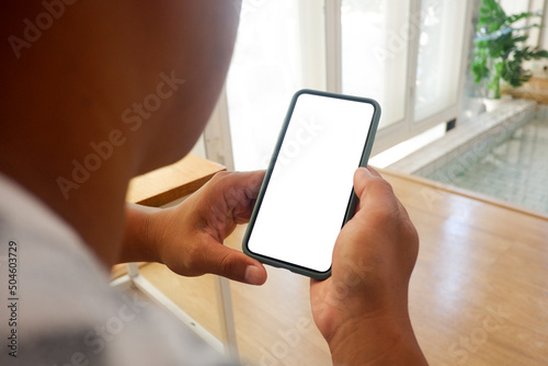 Mockup picture of business man’s hands holding smart phone with white blank screen in modern place