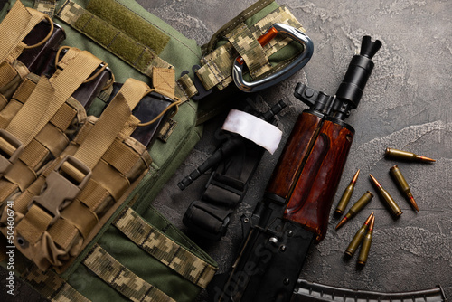 фотографія Military body armor, helmet and ammunition, a Kalashnikov assault rifle with matrons and a first aid tourniquet