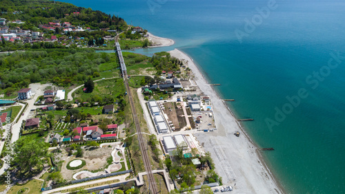 Aerial view of the railway bridge running along the sea coast. The confluence of the Shakhe river with the Black sea. Golovinka, Sochi, Russia.